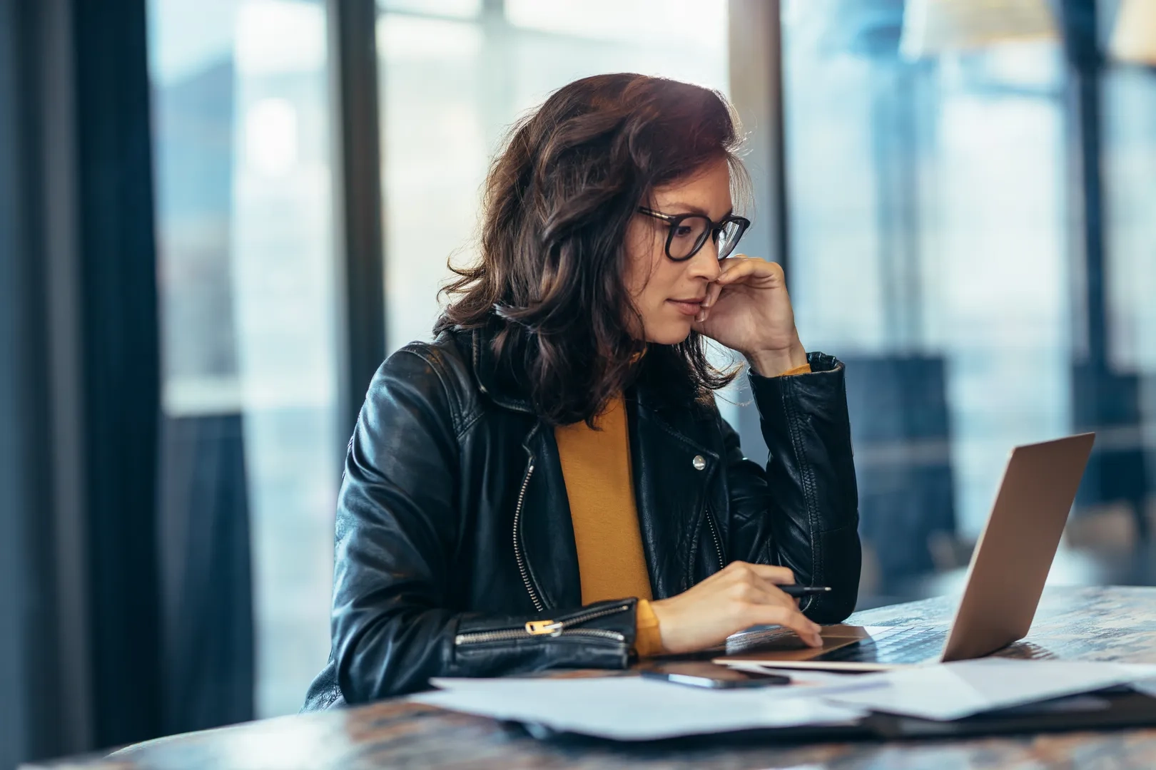 Frau in Lederjacke vor dem Laptop